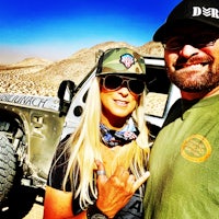 a man and a woman standing next to a jeep