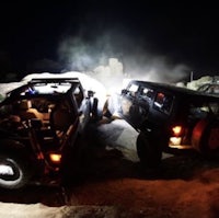 two jeeps parked in the desert at night